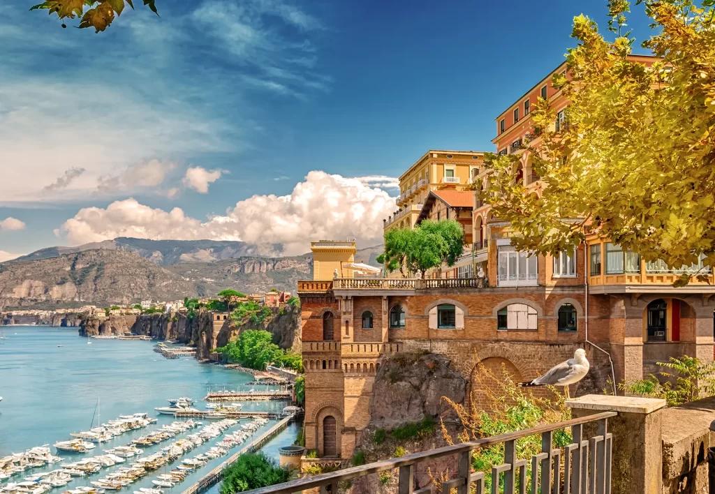 Veduta del porto e delle scogliere con edifici storici a Sorrento, Italia.