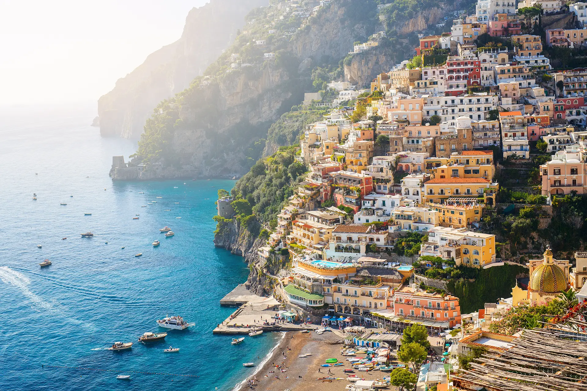 Le case colorate di Positano si arrampicano sulla collina sopra il mare blu della Costiera Amalfitana.