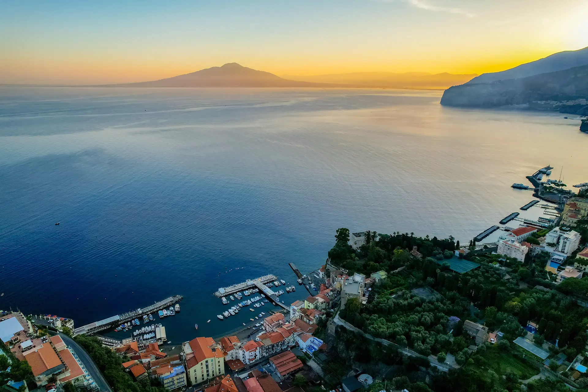 Tramonto sul Golfo di Napoli con vista sul Vesuvio e sulla costa.
