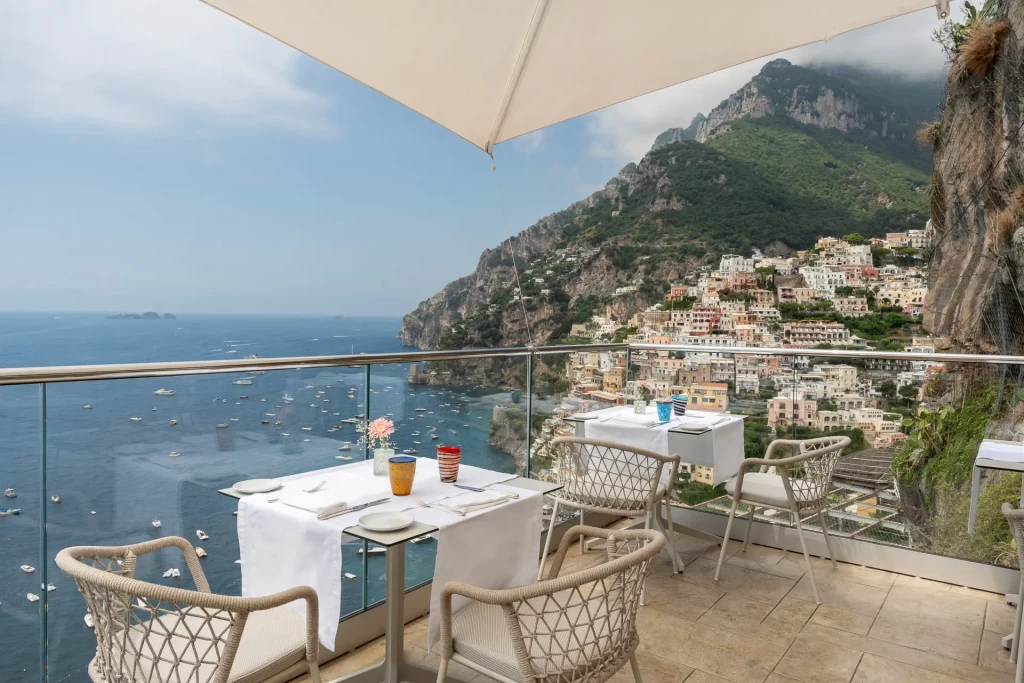 Vista panoramica di un ristorante con terrazza che si affaccia sulla costa amalfitana e Positano.