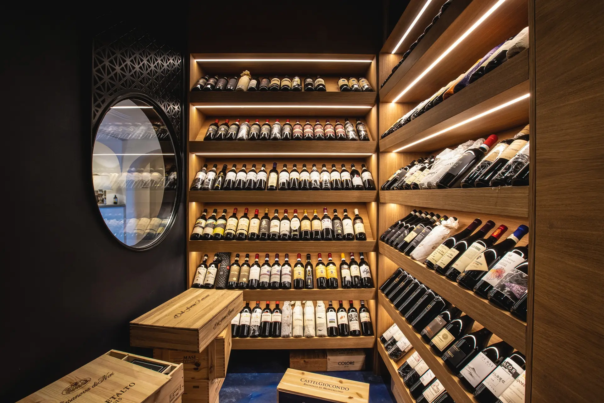 Scaffali di legno illuminati con bottiglie di vino in una cantina elegante.