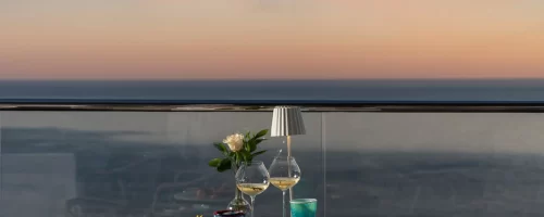 Cena romantica su un balcone con vista mare al tramonto.