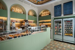 A bright gelato shop interior with a display of desserts and drinks.
