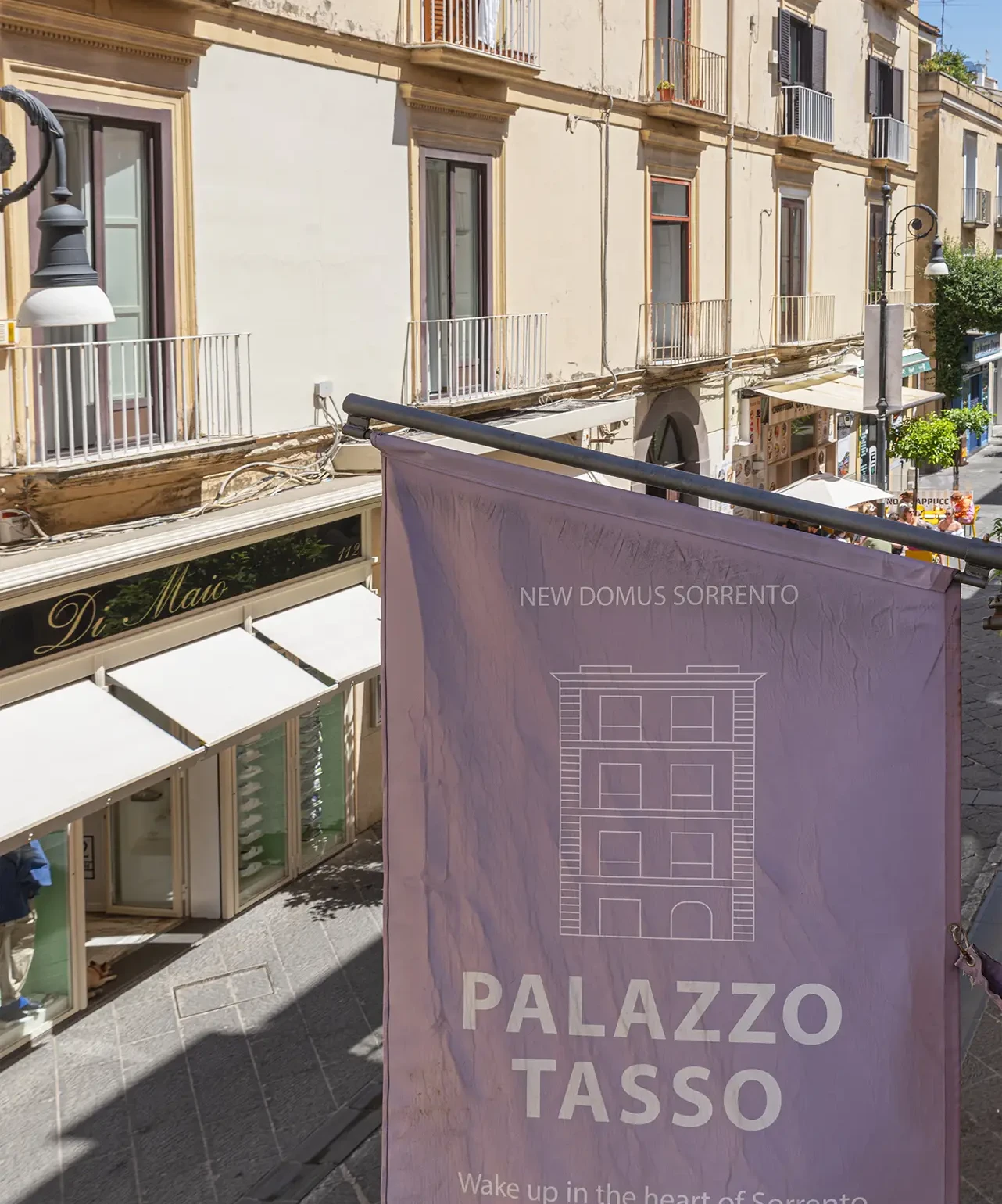 Street view with a Palazzo Tasso banner in Sorrento.