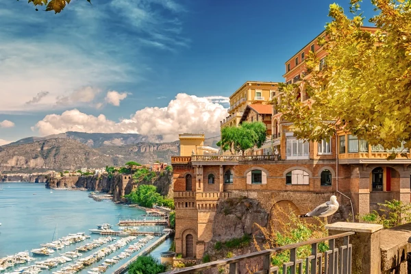 Veduta del porto e delle scogliere con edifici storici a Sorrento, Italia.